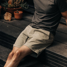 fit model sitting on a deck in The Matlow Short in Arid Eucalyptus Washed Herringbone, Bottoms by Taylor Stitch