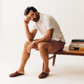 fit model sitting wearing The Short Sleeve California in Vintage Botanical, Wovens by Taylor Stitch