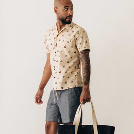 fit model holding a bag wearing The Short Sleeve Hawthorne in Almond Floral, Wovens by Taylor Stitch