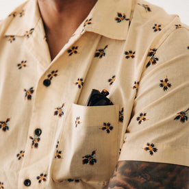 fit model showing off the pocket on The Short Sleeve Hawthorne in Almond Floral, Wovens by Taylor Stitch