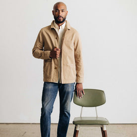 fit model leaning against a chair wearing The Ojai Jacket in Organic Light Khaki Foundation Twill, Outerwear by Taylor Stitch