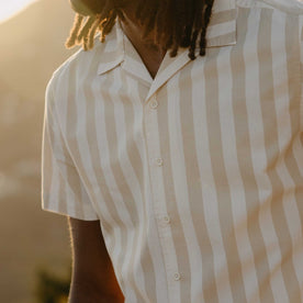 fit model showing off the buttons on The Short Sleeve Davis Shirt in Sandbar Stripe, Wovens by Taylor Stitch