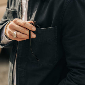 fit model putting his glasses in the pocket of The Station Jacket in Dark Navy Broken Twill, Outerwear by Taylor Stitch