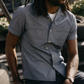 fit model sitting wearing The Tulum Shirt in Midnight Stripe, Wovens by Taylor Stitch