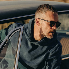 fit model coming out of a car wearing The Apres Hoodie in Washed Indigo Terry, Knits by Taylor Stitch