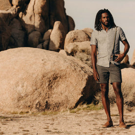 fit model posing by the rocks wearing The Camp Short in Coal Chipped Canvas, Bottoms by Taylor Stitch