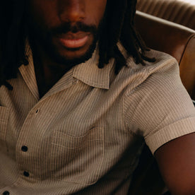 fit model sitting in a car wearing The Conrad Shirt in Black Coffee Stripe, Wovens by Taylor Stitch