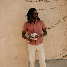 fit model leaning against the wall wearing The Conrad Shirt in Fired Brick Dobby, Wovens by Taylor Stitch