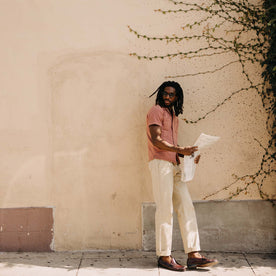 fit model leaning against the wall wearing The Conrad Shirt in Fired Brick Dobby, Wovens by Taylor Stitch