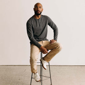 fit model sitting on a stool wearing The Heavy Bag Henley in Heather Grey, Knits by Taylor Stitch