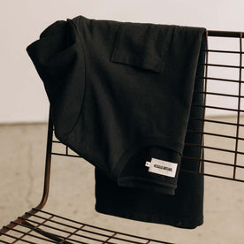 editorial image of The Heavy Bag Tee in Black on a chair, Knits by Taylor Stitch