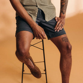 fit model sitting on a stool wearing The Matlow Short in Dark Navy Herringbone, Bottoms by Taylor Stitch