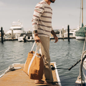 fit model standing on a dock in The Colton Crew in Oat Heathered Stripe, Knits by Taylor Stitch