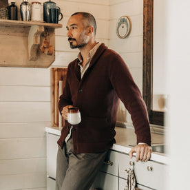 fit model leaning against the counter wearing The Crawford Sweater in Black Cherry, Knits by Taylor Stitch