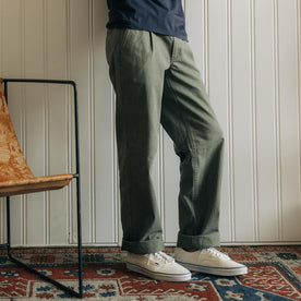 fit model leaning against the wall wearing The Matlow Pant in Dried Sage Pigment Herringbone, Bottoms by Taylor Stitch