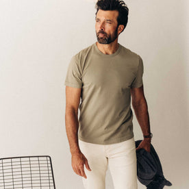 fit model sitting leaning against the wall in The Organic Cotton Tee in Sage, Knits by Taylor Stitch