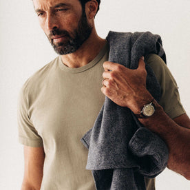 fit model with a jacket over his shoulder wearing The Organic Cotton Tee in Sage, Knits by Taylor Stitch