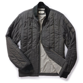 flatlay of The Able Jacket in Faded Black Quilted Nylon, shown half zipped, Outerwear by Taylor Stitch