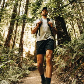 fit model walking down the hill wearing The Challenge Cargo Short in Black, Bottoms by Taylor Stitch