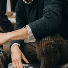 fit model with rolled up sleeves in The Lodge Sweater in Black Pine, Knits by Taylor Stitch