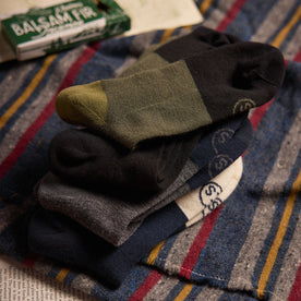 editorial image of The Merino Sock in Olive and other socks stacked on top of each other, Accessories by Taylor Stitch