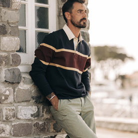 fit model leaning against the wall wearing The Rugby in Dark Navy Stripe, Knits by Taylor Stitch