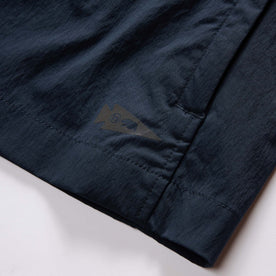 material shot of the brand tag on The Deploy Packable Shell in Dark Navy, Outerwear by Taylor Stitch