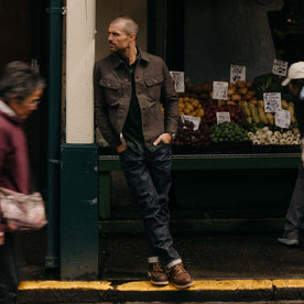 fit model leaning against the wall wearing The Long Haul Jacket in Peat Nep Herringbone, Outerwear by Taylor Stitch