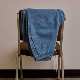 editorial image of The Apres Pant in Washed Indigo Sashiko hanging on a chair, Bottoms by Taylor Stitch