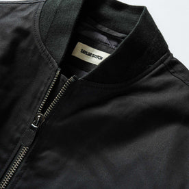 material shot of the ribbed neck opening on The Insulated Bomber Jacket in Coal Dry Wax, Outerwear by Taylor Stitch