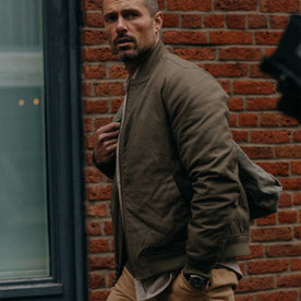 fit model walking in The Insulated Bomber Jacket in Fatigue Olive Dry Wax, Outerwear by Taylor Stitch