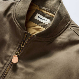 material shot of the ribbed neck opening on The Insulated Bomber Jacket in Fatigue Olive Dry Wax, Outerwear by Taylor Stitch