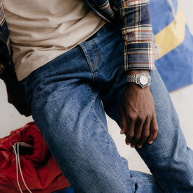 fit model sitting wearing The Democratic Jean in Mid Wash Organic Selvedge, Bottoms by Taylor Stitch