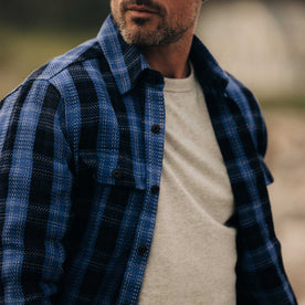 fit model with his shirt open wearing The Division Shirt in Rinsed Indigo Plaid, Wovens by Taylor Stitch