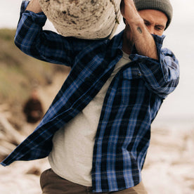 fit model holding a log wearing The Division Shirt in Rinsed Indigo Plaid, Wovens by Taylor Stitch