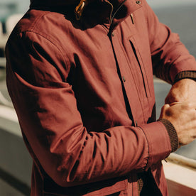 fit model leaning on a railing wearing The Explorer Jacket in Red Wine Dry Wax, Outerwear by Taylor Stitch