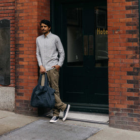 fit model leaning against the wall wearing The Foundation Tote in Organic Navy, Accessories by Taylor Stitch