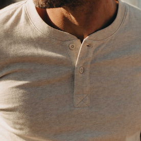 fit model showing off buttons on The Organic Cotton Henley in Heather Oat, Knits by Taylor Stitch