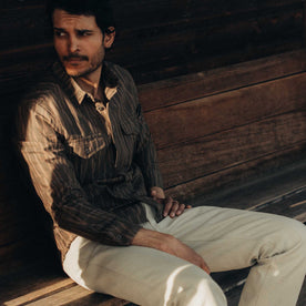 fit model sitting wearing The Saddler Shirt in Bark Print Broken Twill, Wovens by Taylor Stitch