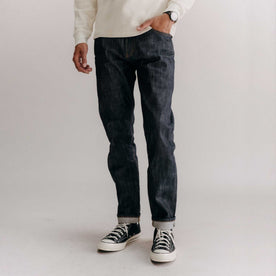 fit model with his hand in his pocket wearing The Slim Jean in Rigid Organic Selvedge, Bottoms by Taylor Stitch