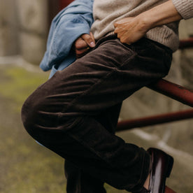 fit model sitting wearing The Carnegie Pant in Soil Corduroy, Bottoms by Taylor Stitch