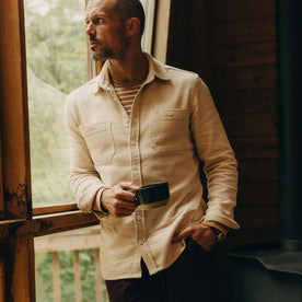 fit model leaning against the wall wearing The Utility Shirt in Natural Sashiko, Wovens by Taylor Stitch