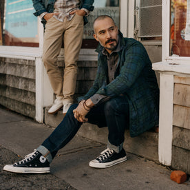 fit model sitting on a stoop in The Ojai Jacket in Blackwatch Plaid Diamond Quilt, Outerwear by Taylor Stitch