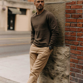 fit model leaning against a wall in The Organic Cotton Waffle Crew in Fatigue Olive, Knits by Taylor Stitch