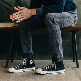 fit model sitting in The Slim Jean in Black 1-Year Wash Selvage Denim, Bottoms by Taylor Stitch