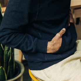 fit model with his hands in the kangaroo pocket of The Apres Hoodie in Indigo Terry, Knits by Taylor Stitch