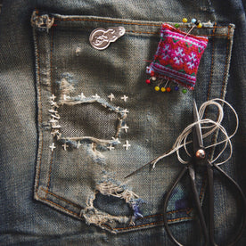 A pair of old jeans patched using the sashiko mending method, Accessories by Taylor Stitch