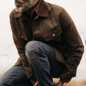 fit model crouching wearing The Long Haul Jacket in Dark Khaki Waxed Canvas, Outerwear by Taylor Stitch