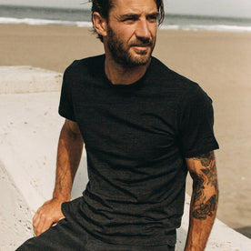 fit model sitting wearing The Merino Tee in Heather Black, Knits by Taylor Stitch