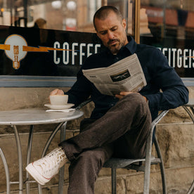 fit model sitting on the porch in The Carnegie Pant in Peat Herringbone, Bottoms by Taylor Stitch